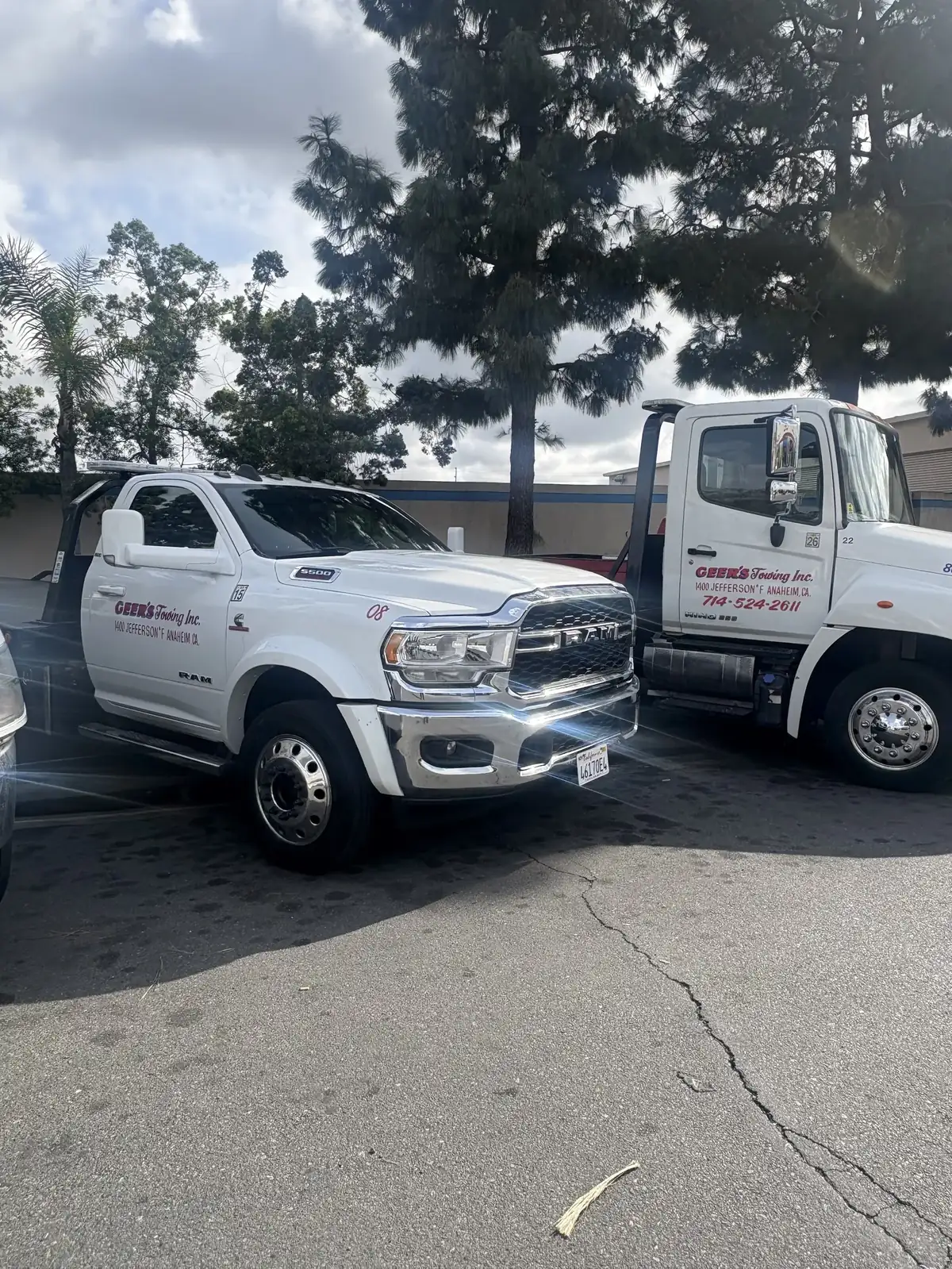 A Geer's Towing Ram 5500 wheel-lift and Hino flatbed tow truck parked at the Anaheim yard