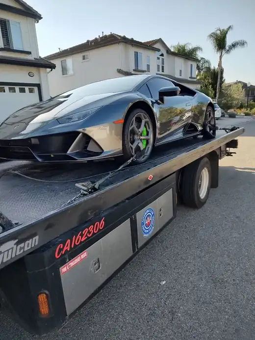 Geer's Towing flatbed carefully transporting a Lamborghini Huracan supercar
