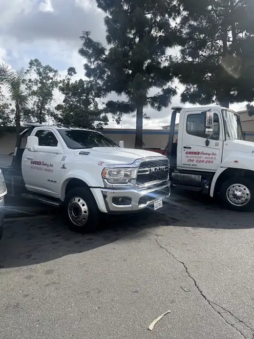 A Geer's Towing Ram 5500 wheel-lift and Hino flatbed tow truck parked at the Anaheim yard
